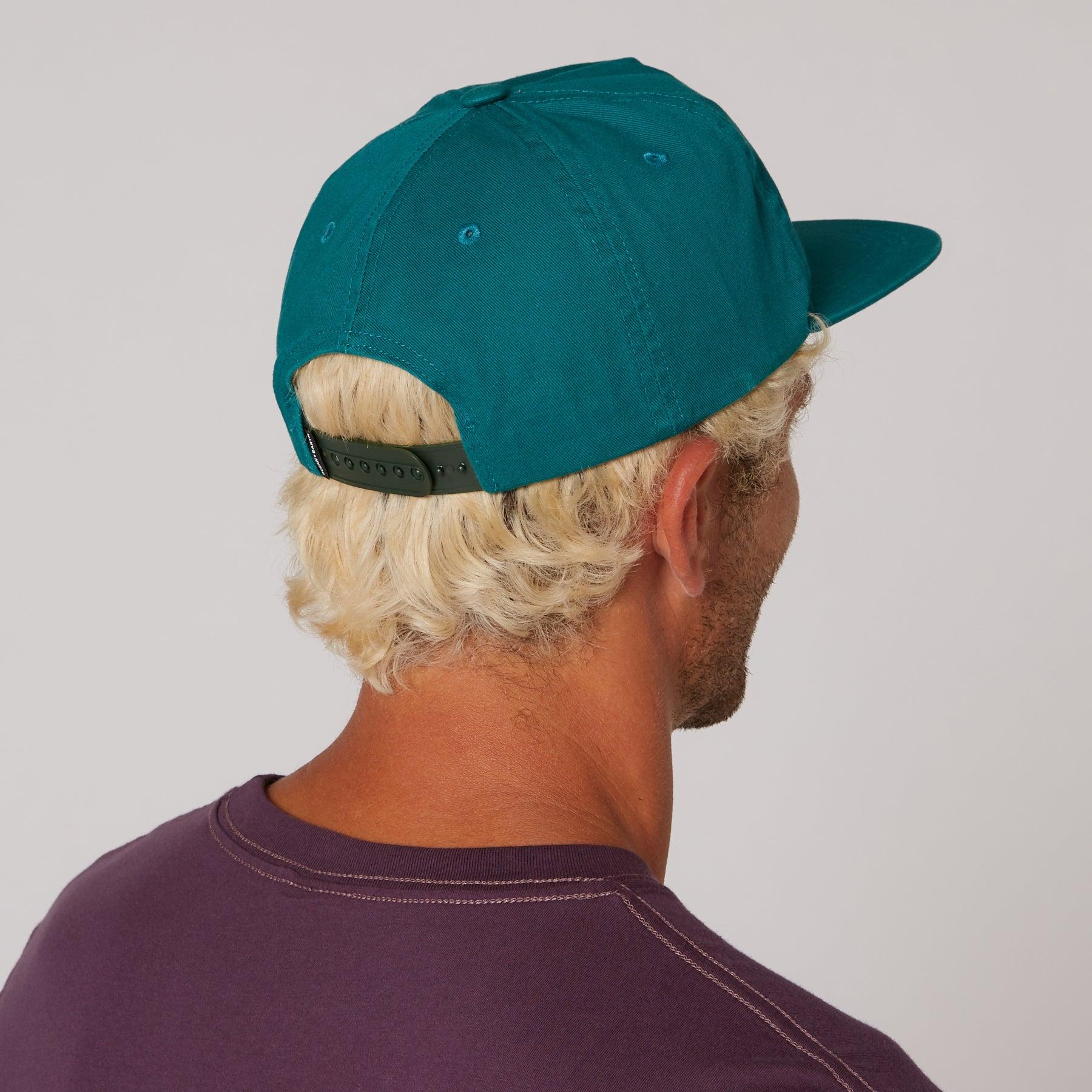 Man wearing teal Corp Cap