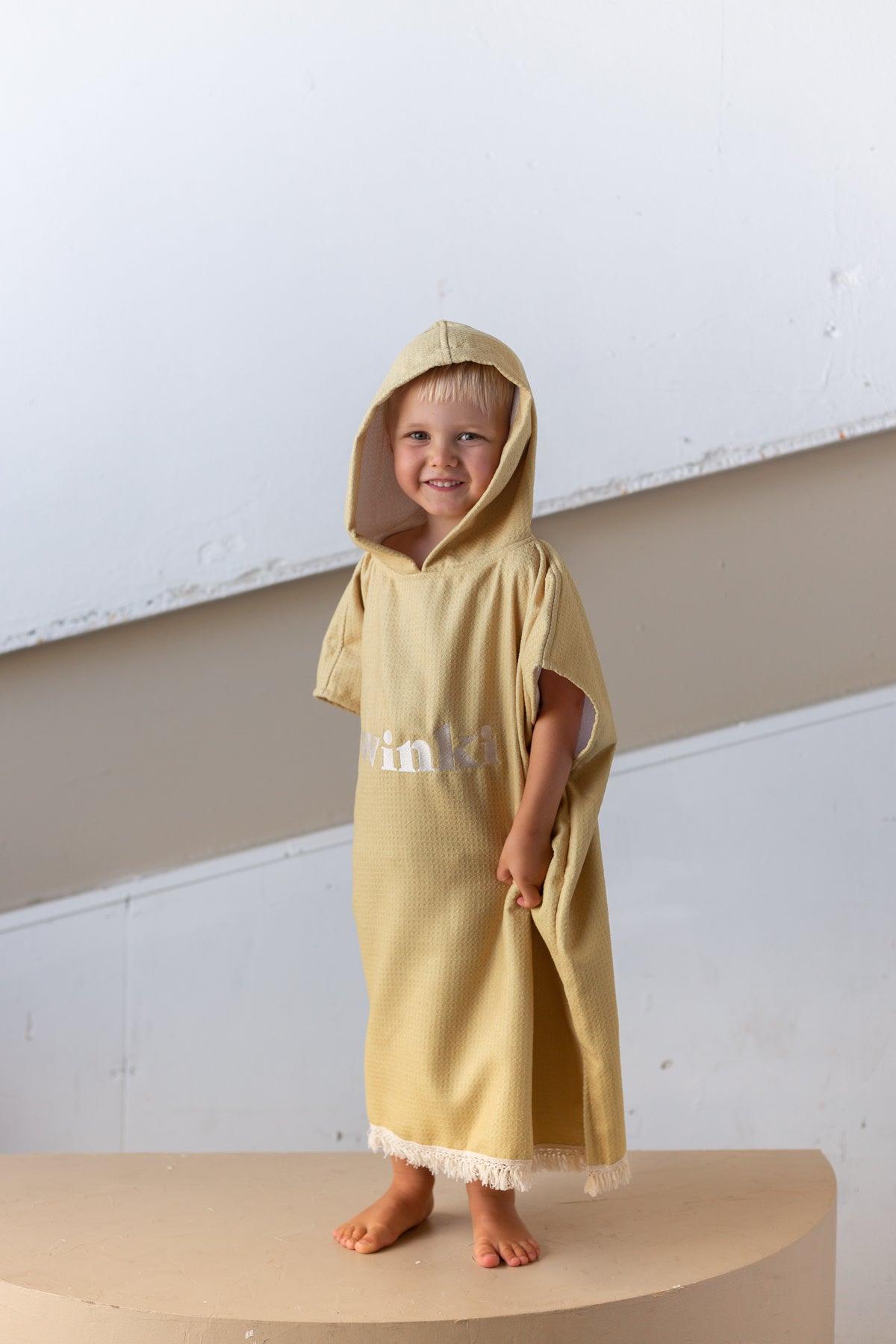 Child in mustard hooded towel