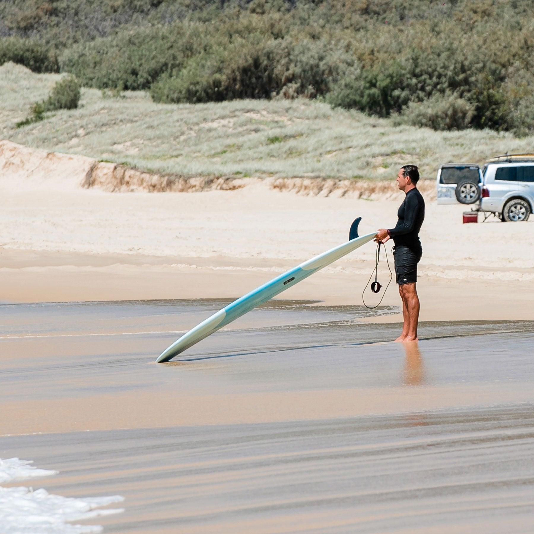 Surfer with Longboard at Beach