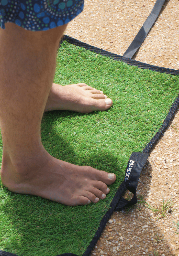 Feet on sand mat on dirt