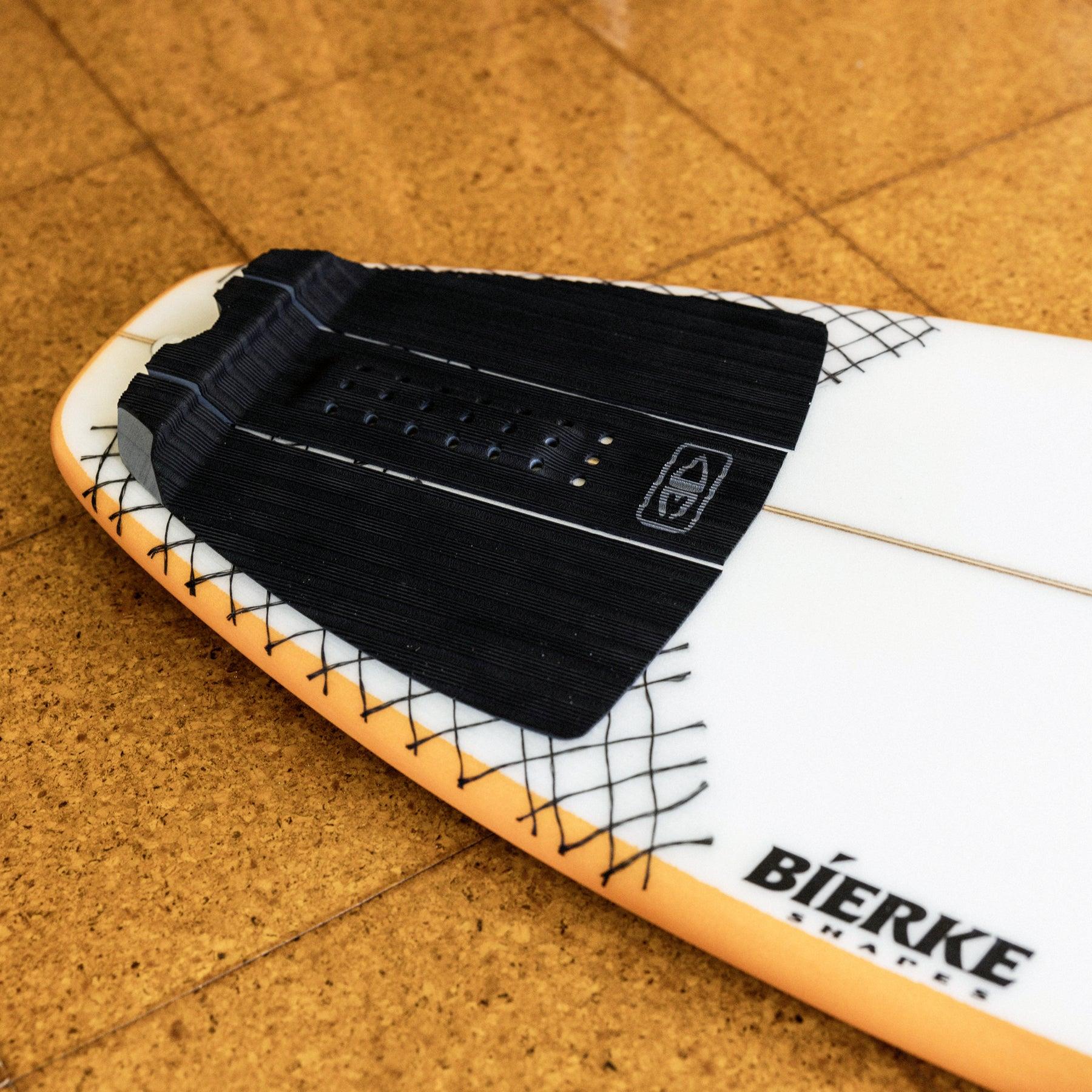 Tail pad on surfboard in water
