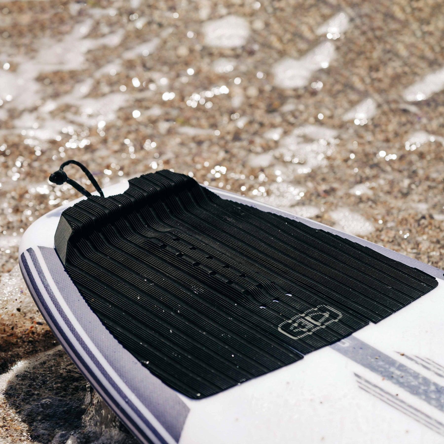 Tail pad on surfboard in water