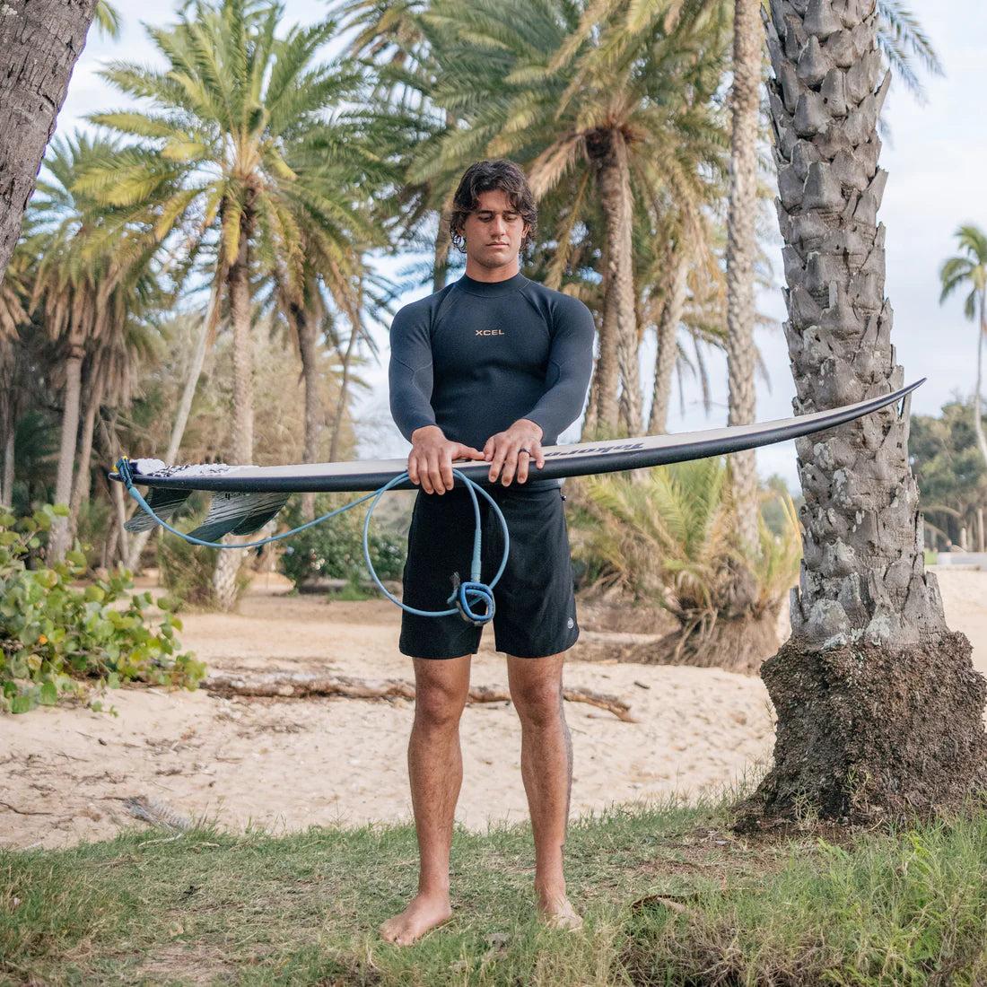 Man holding surfboard vertically