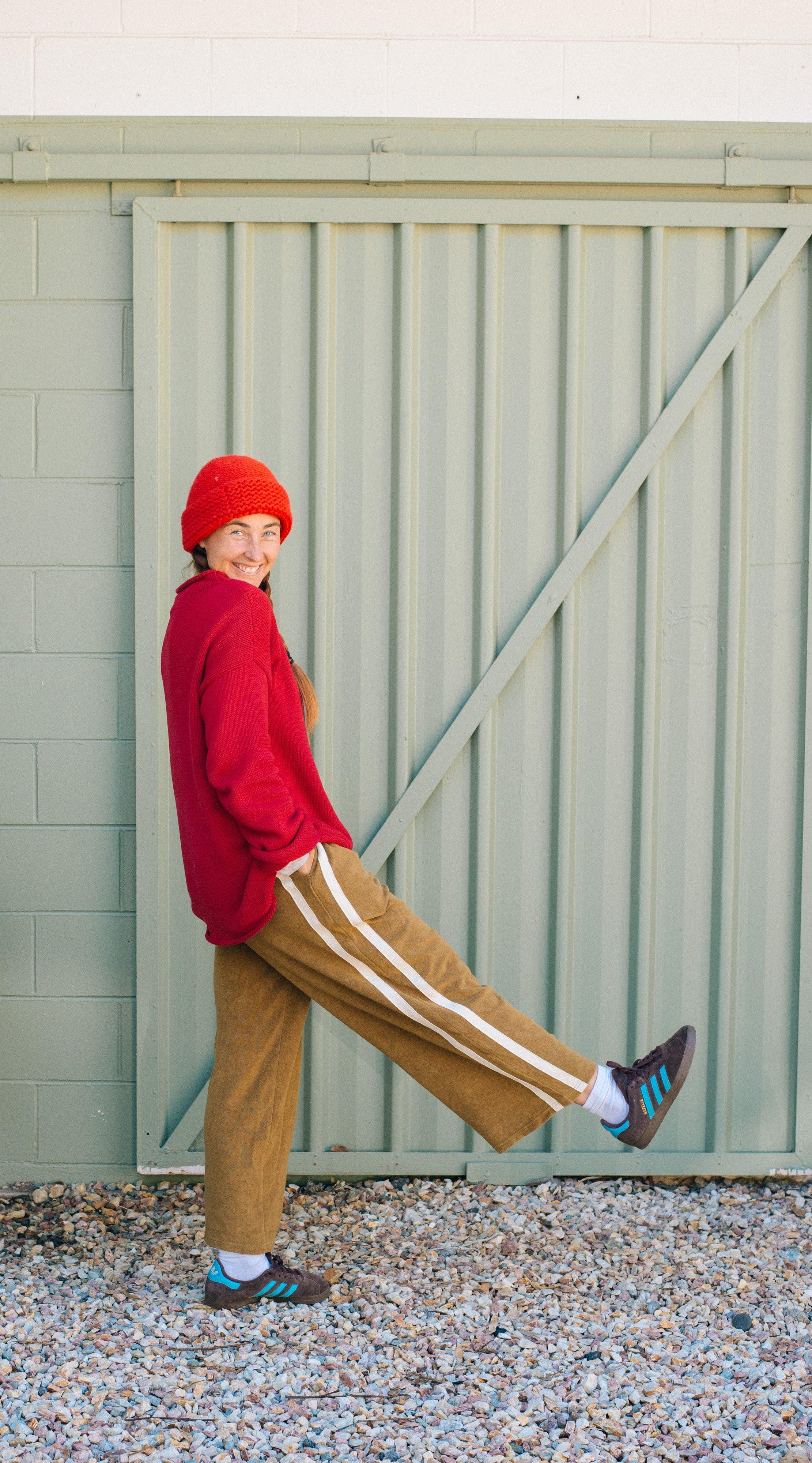 Model in red sweater, green pants