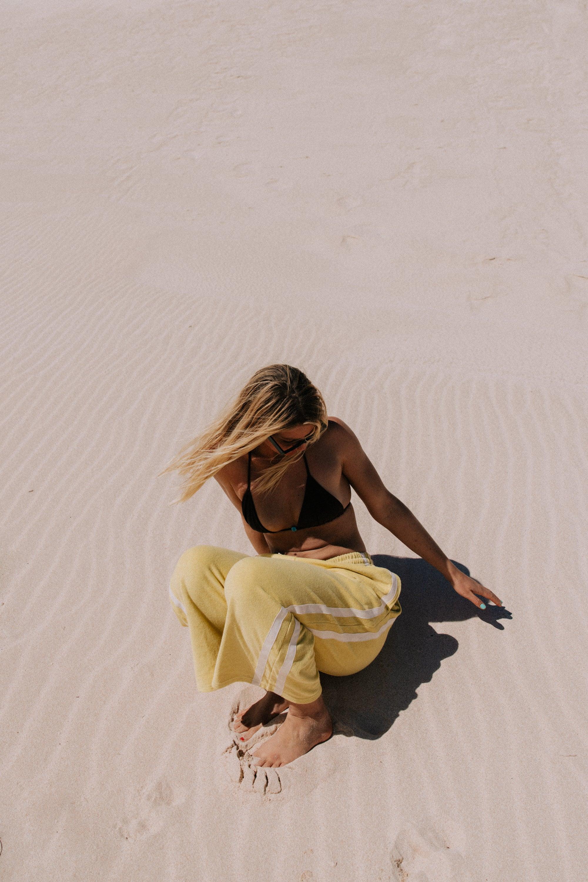 Model sitting in yellow pants