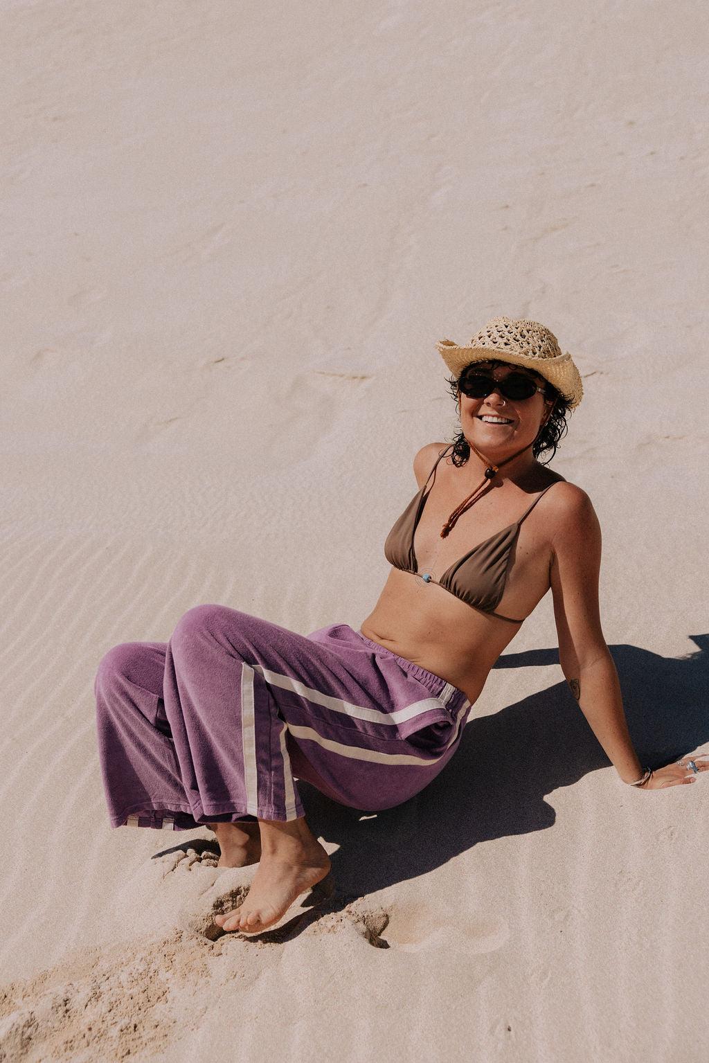 Model on sand in purple pants