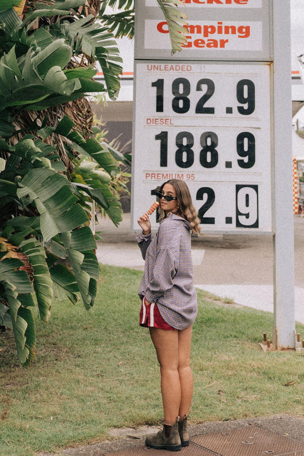 Model in flannel shirt by gas station
