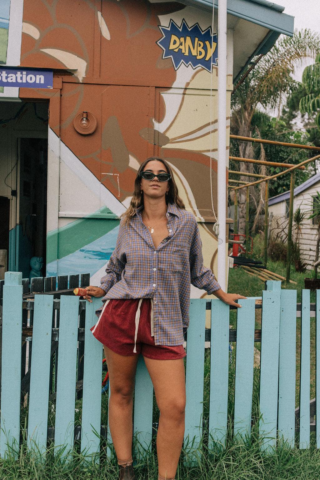 Model in flannel shirt by fence