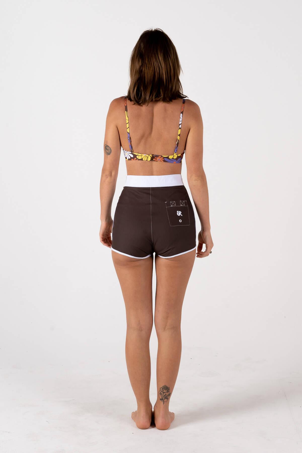 Model adjusting hair, back view