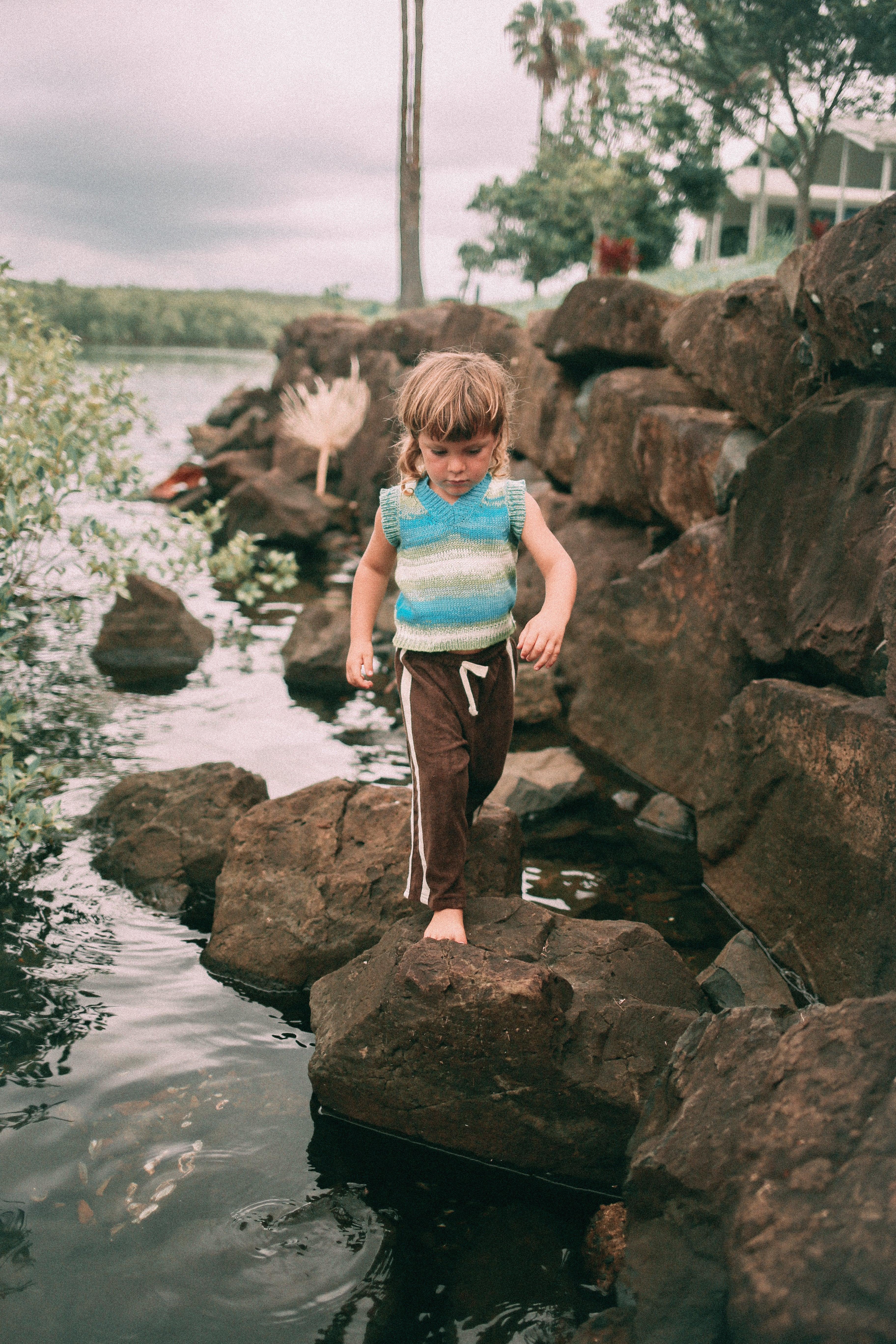 Child on rocks in vest