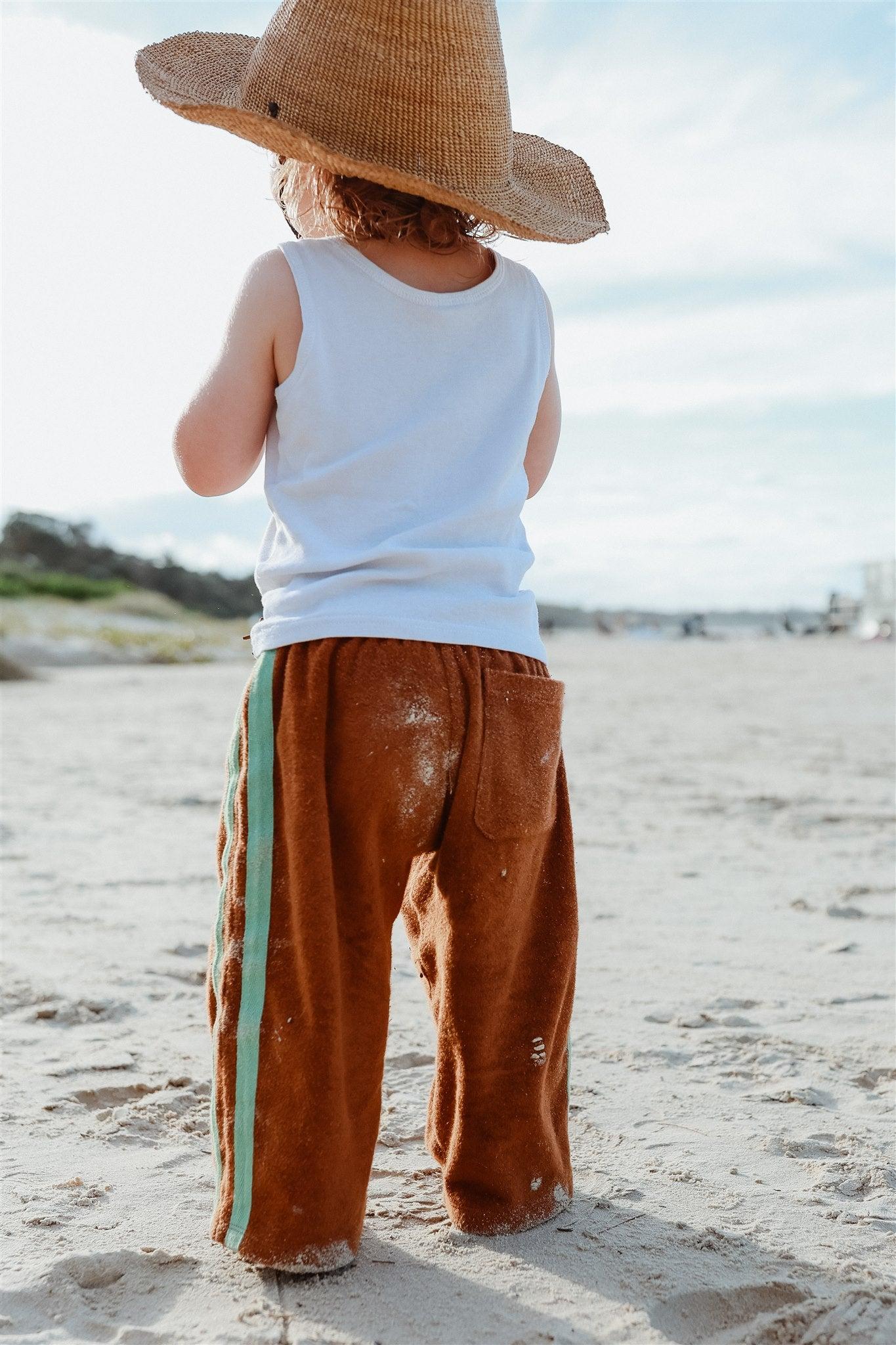 Child with hat on beach