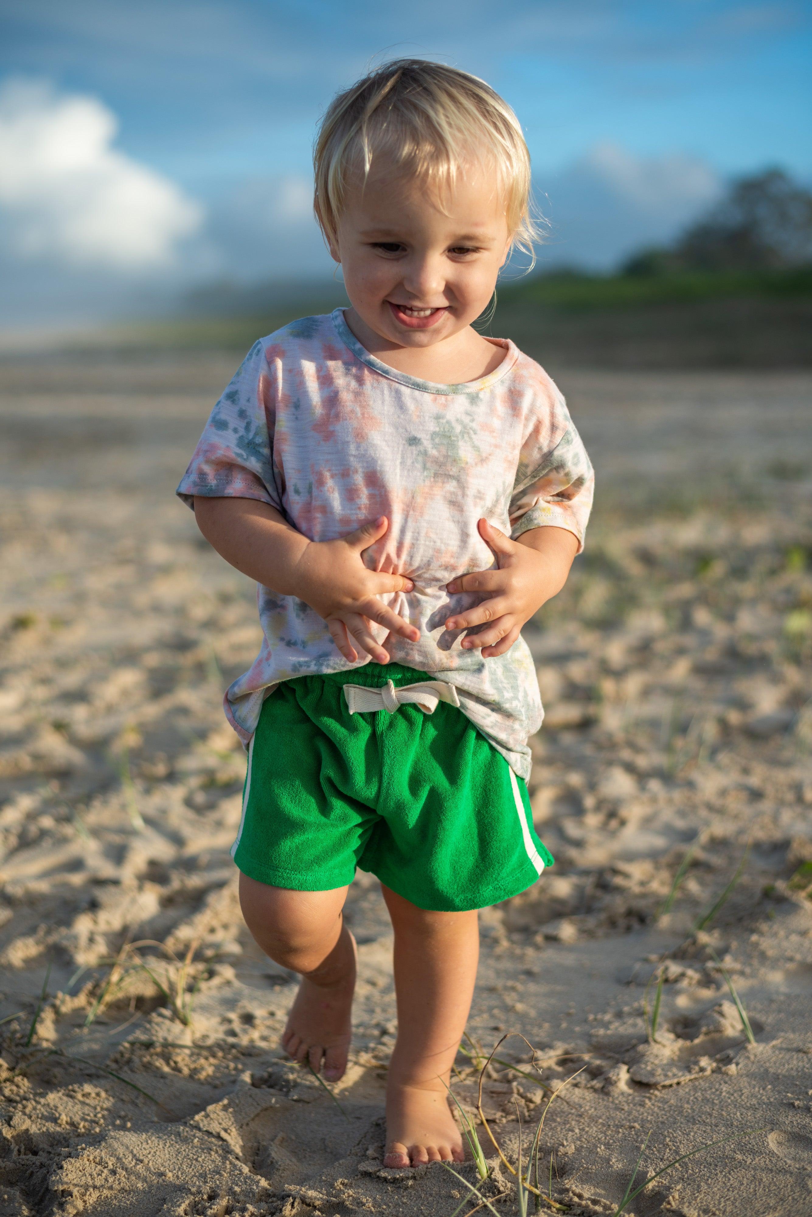 Child in green shorts running