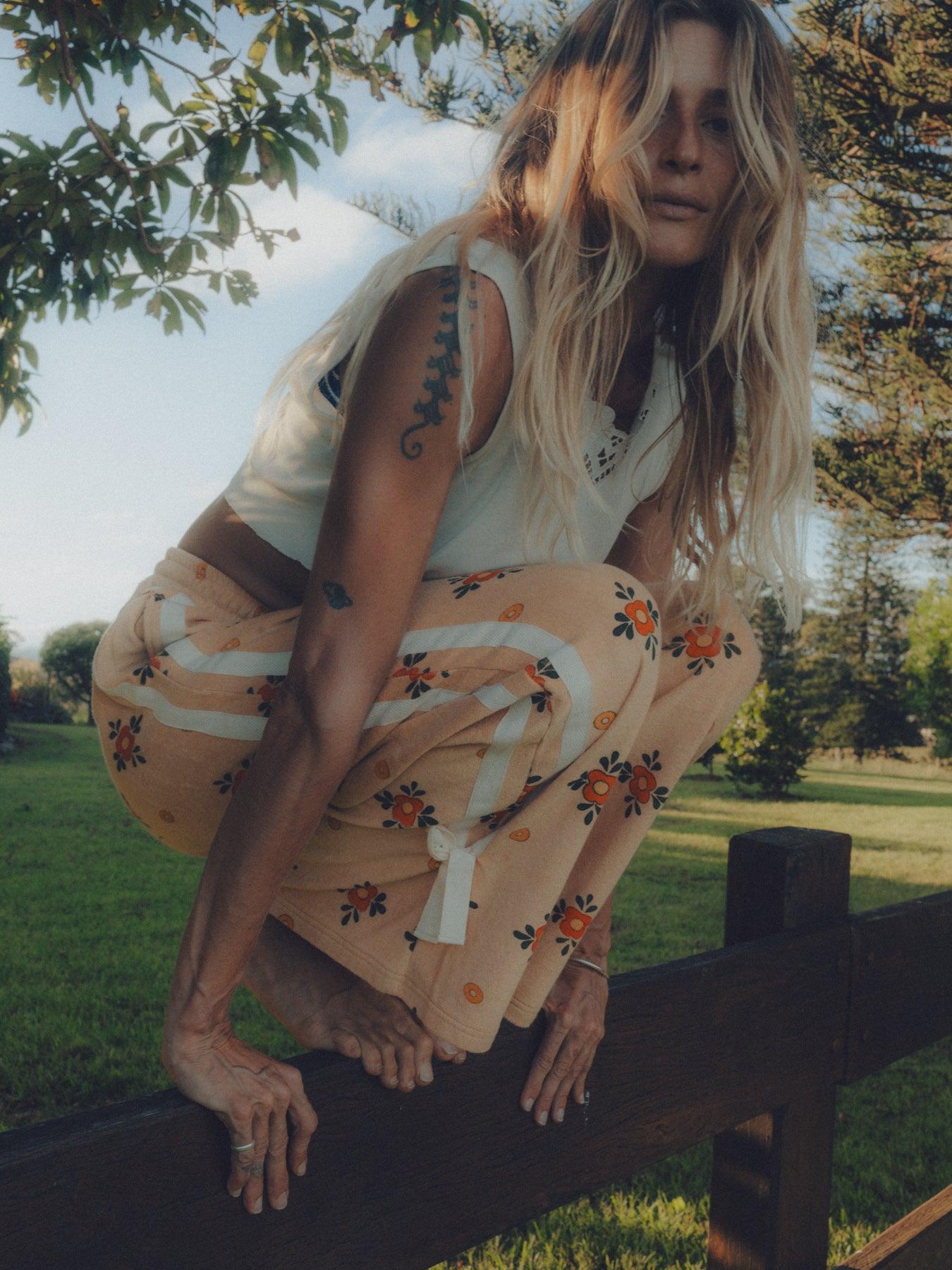 Model crouching on fence