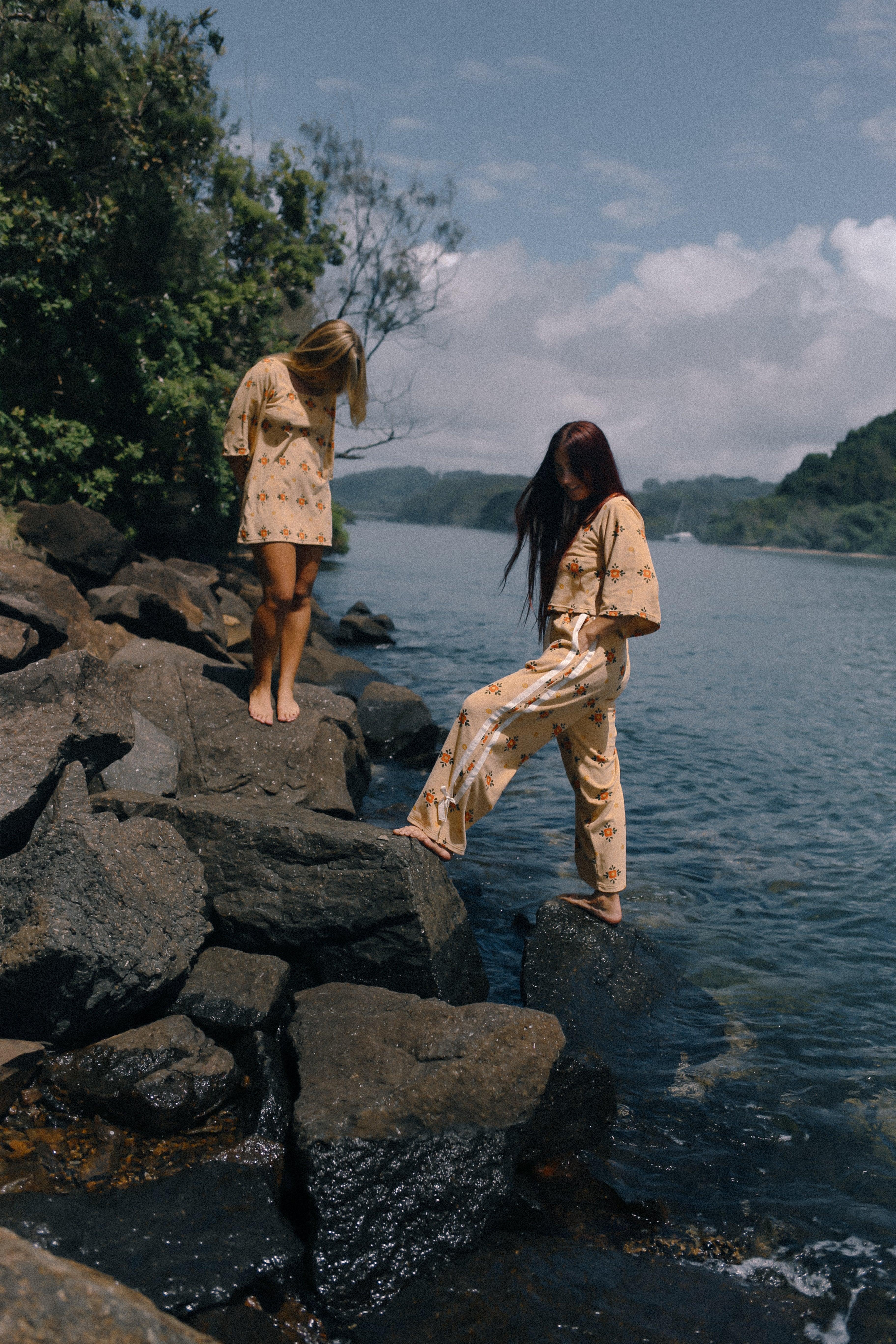 Two models on rocks by water
