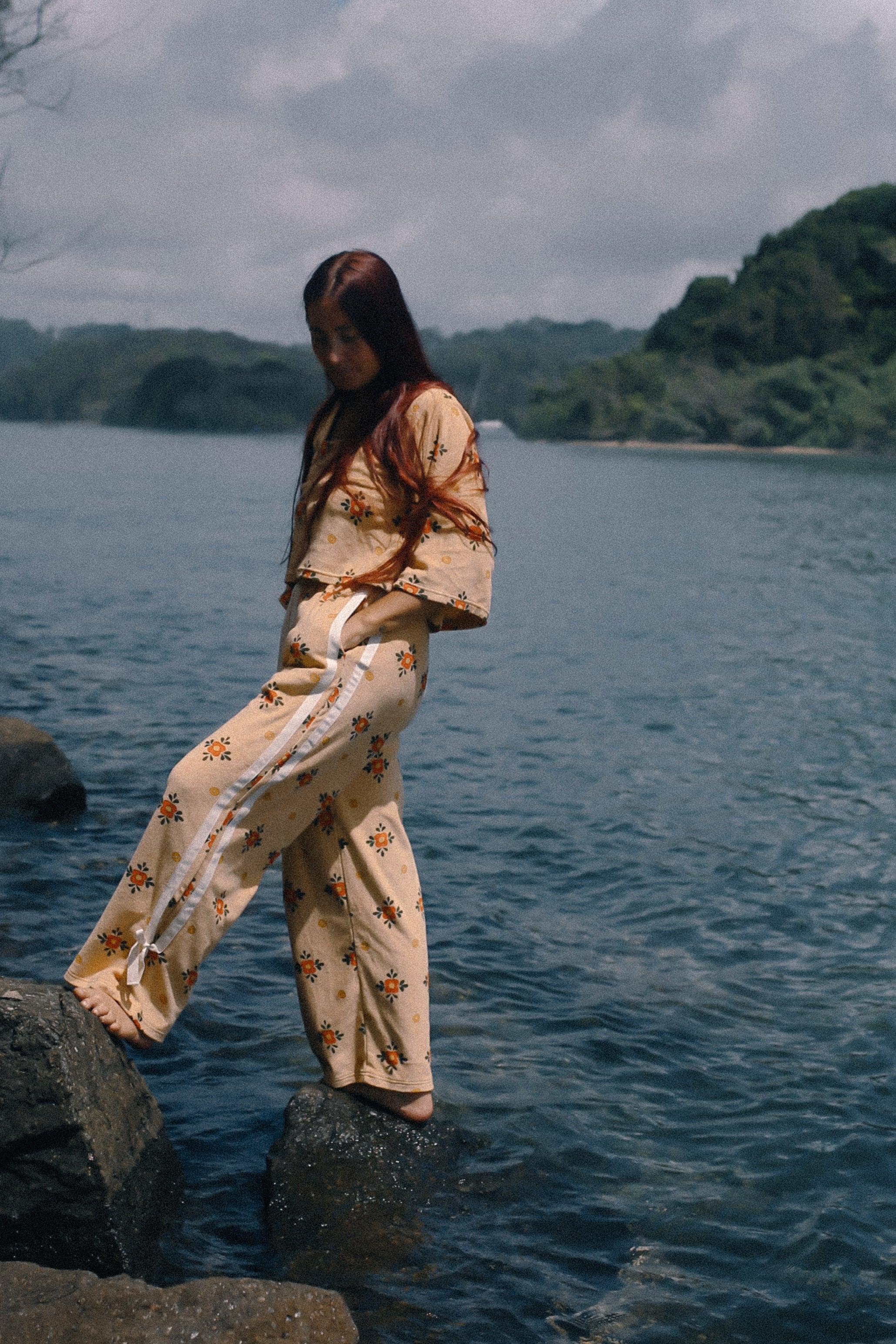 Model on rocks by water