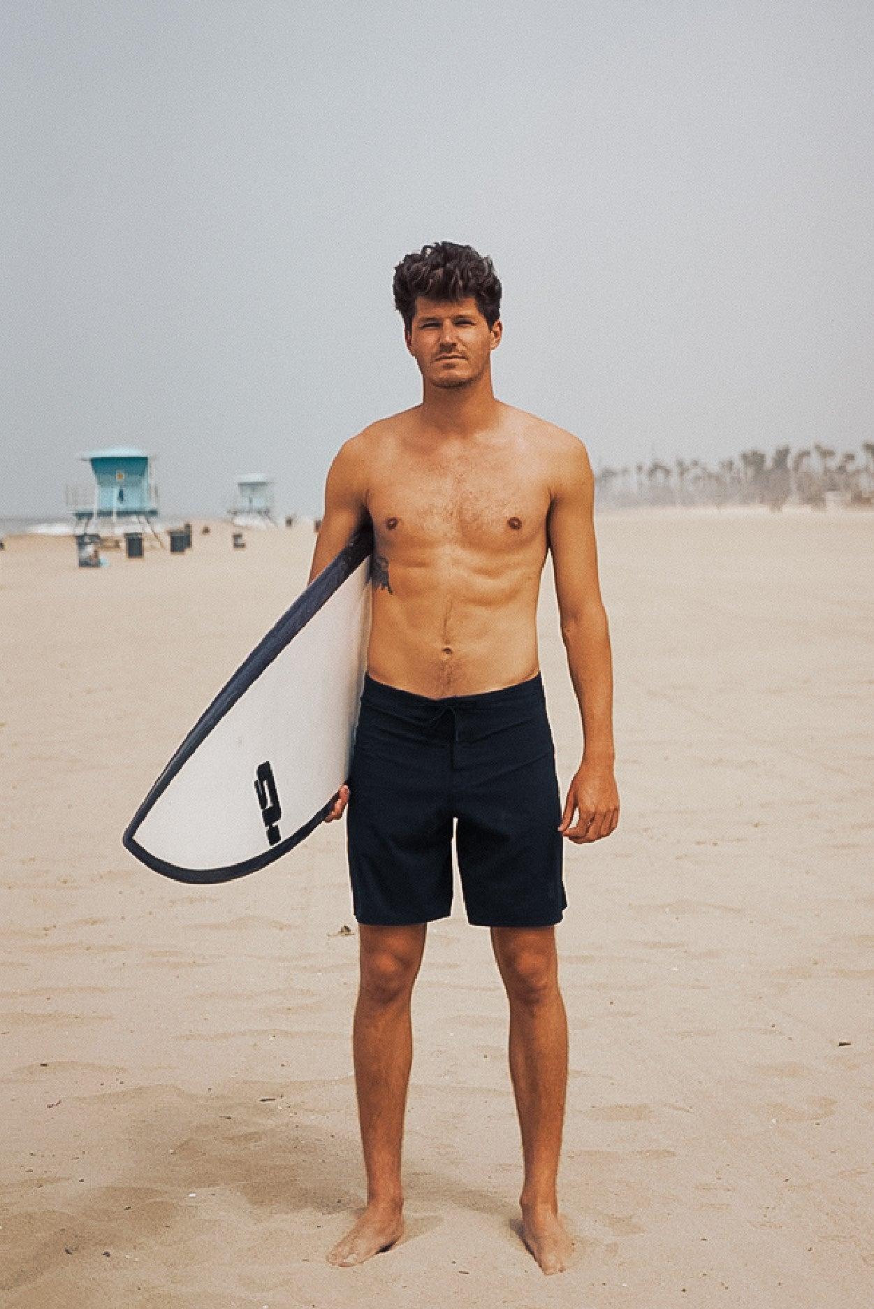 Man holding surfboard on beach