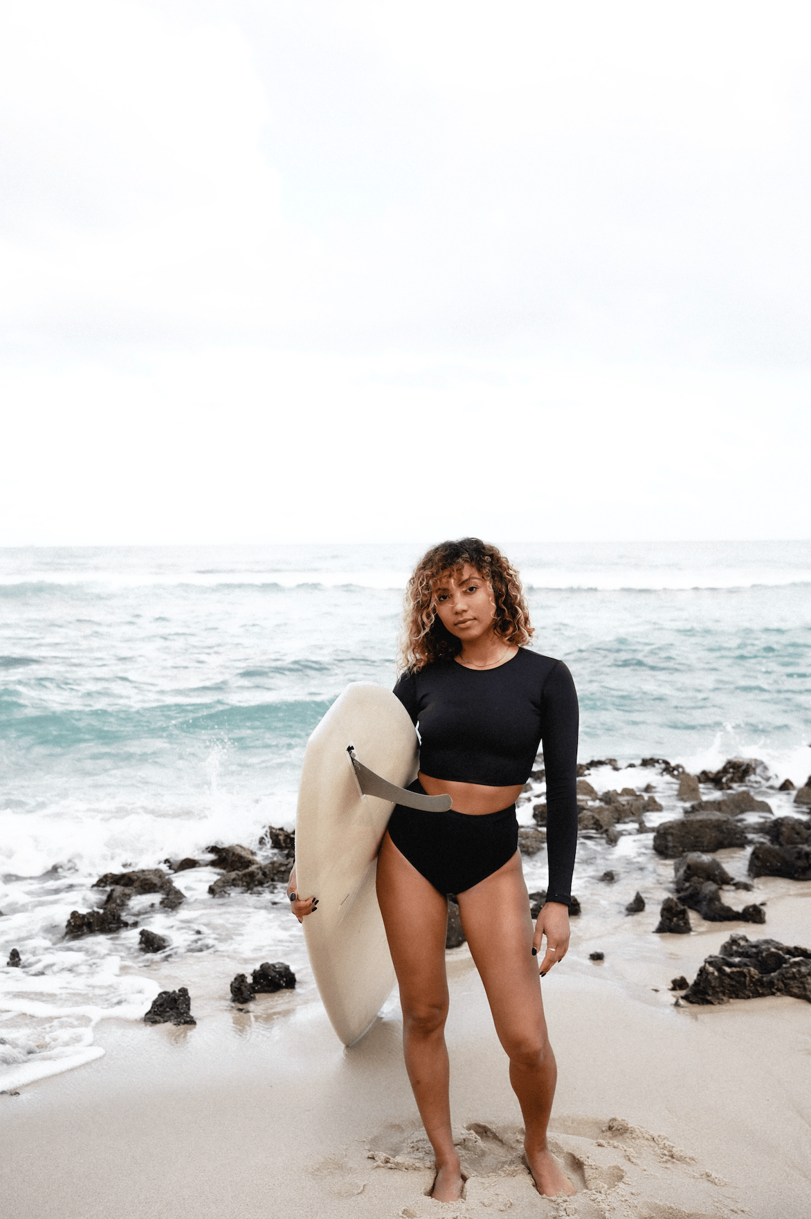 Model with surfboard on beach