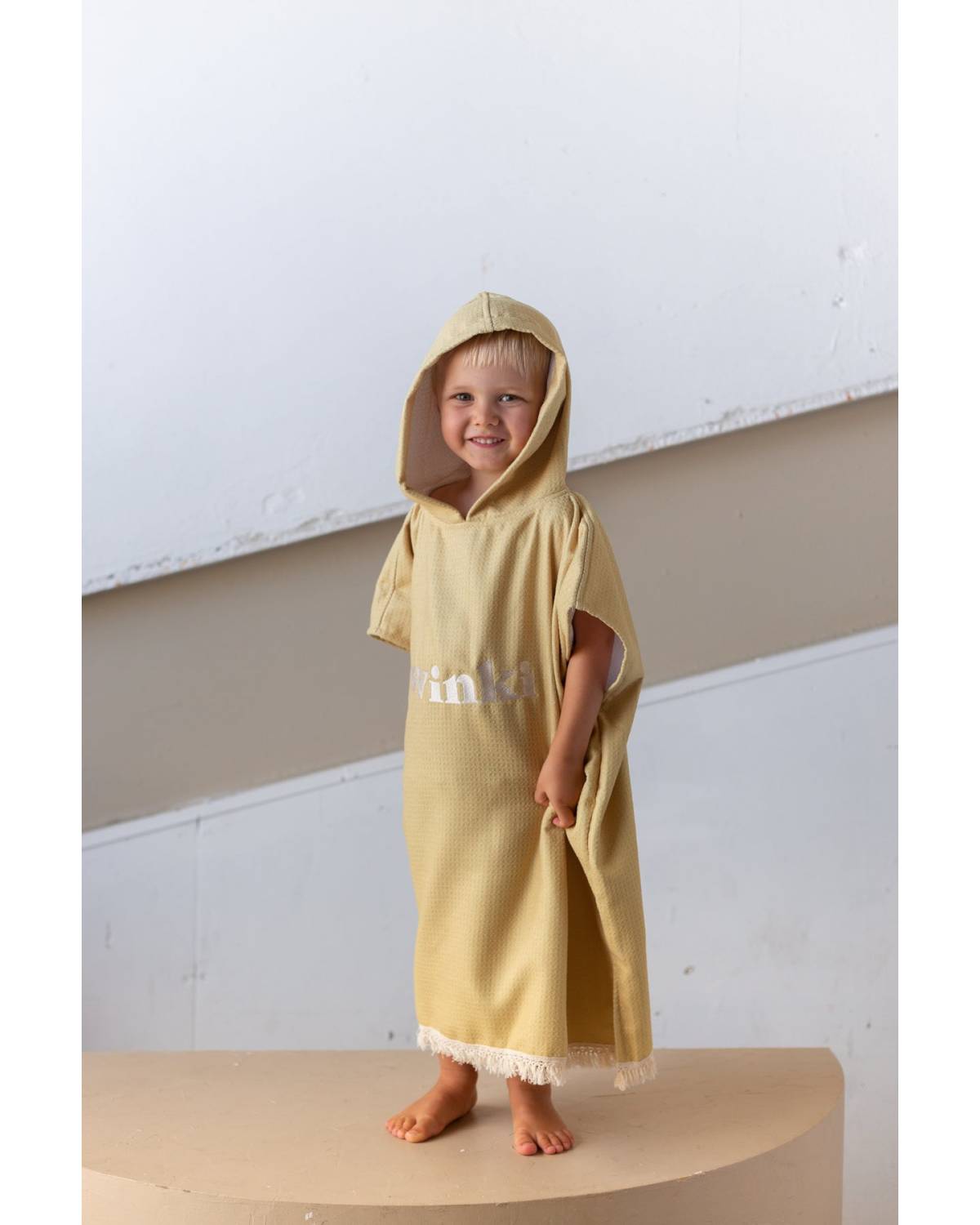 Child in mustard hooded towel