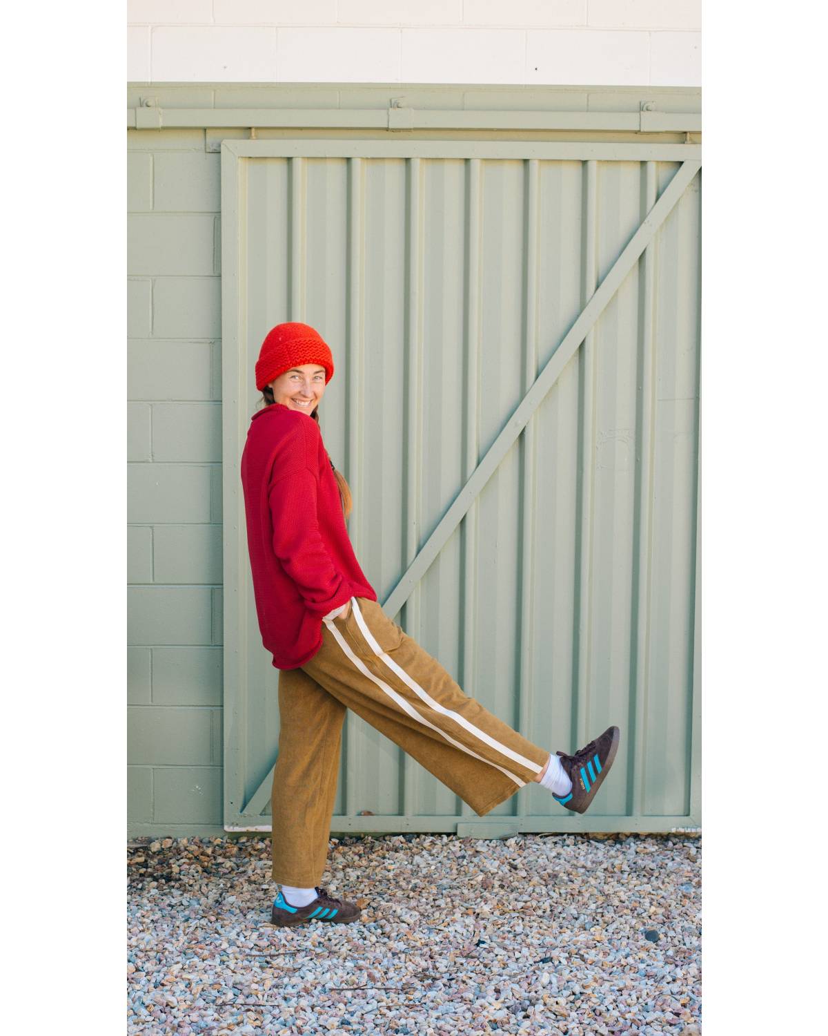 Model in red sweater, green pants