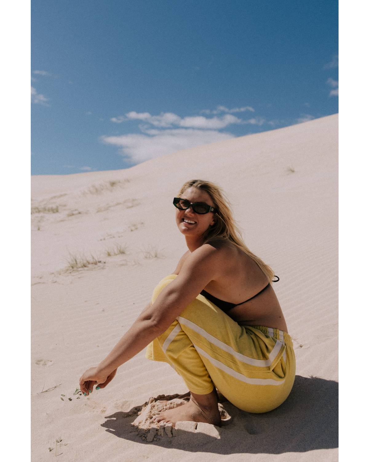Model in yellow pants on sand