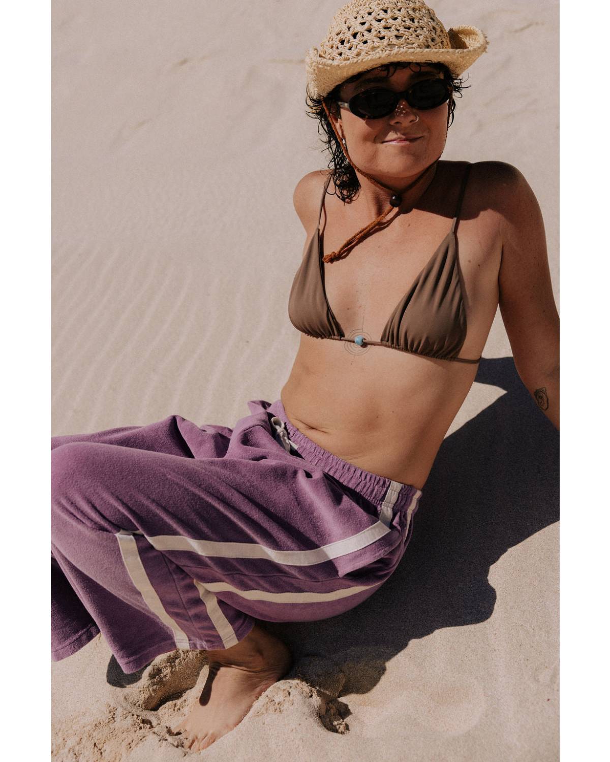 Model sitting in purple pants