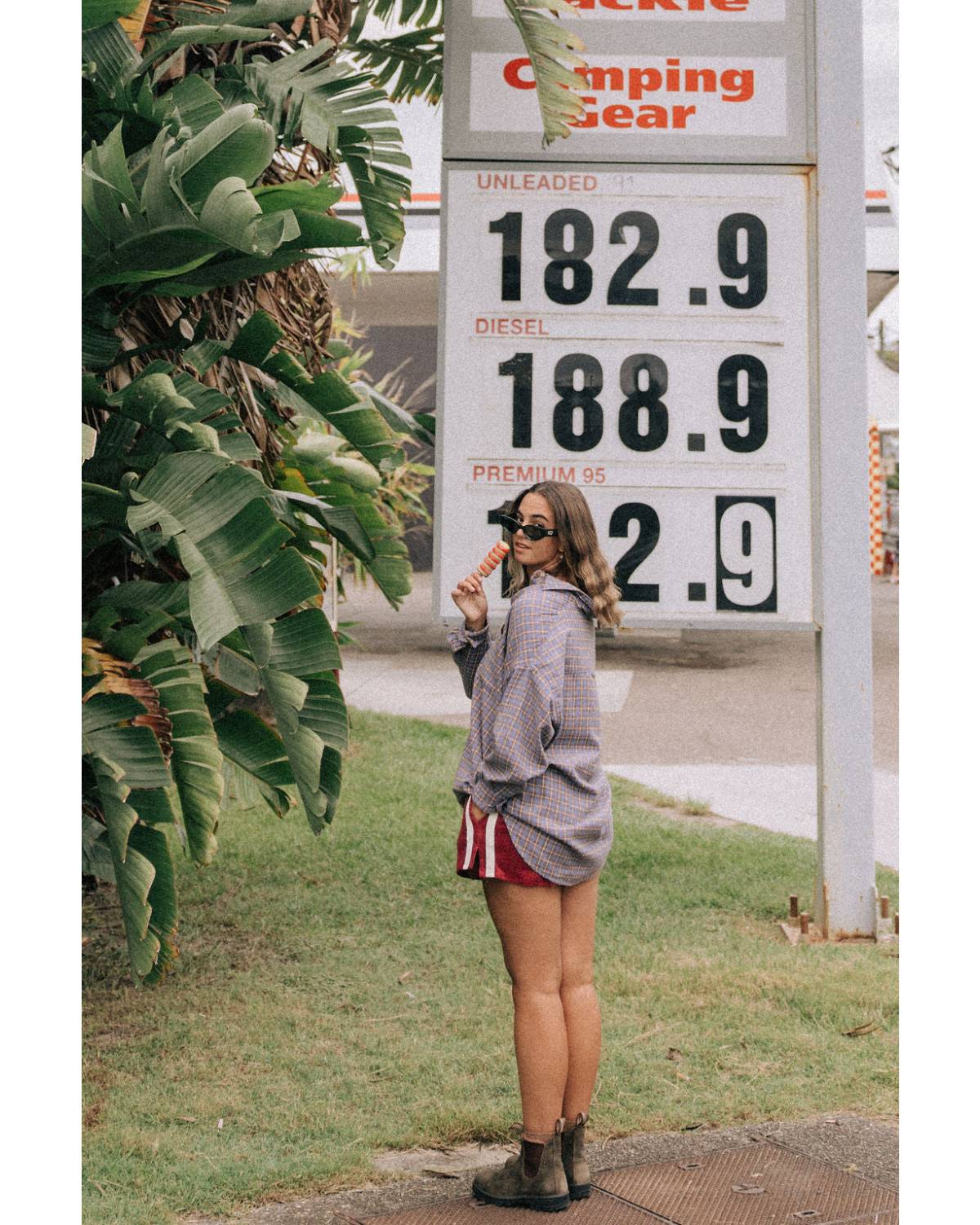 Model in flannel shirt by gas station