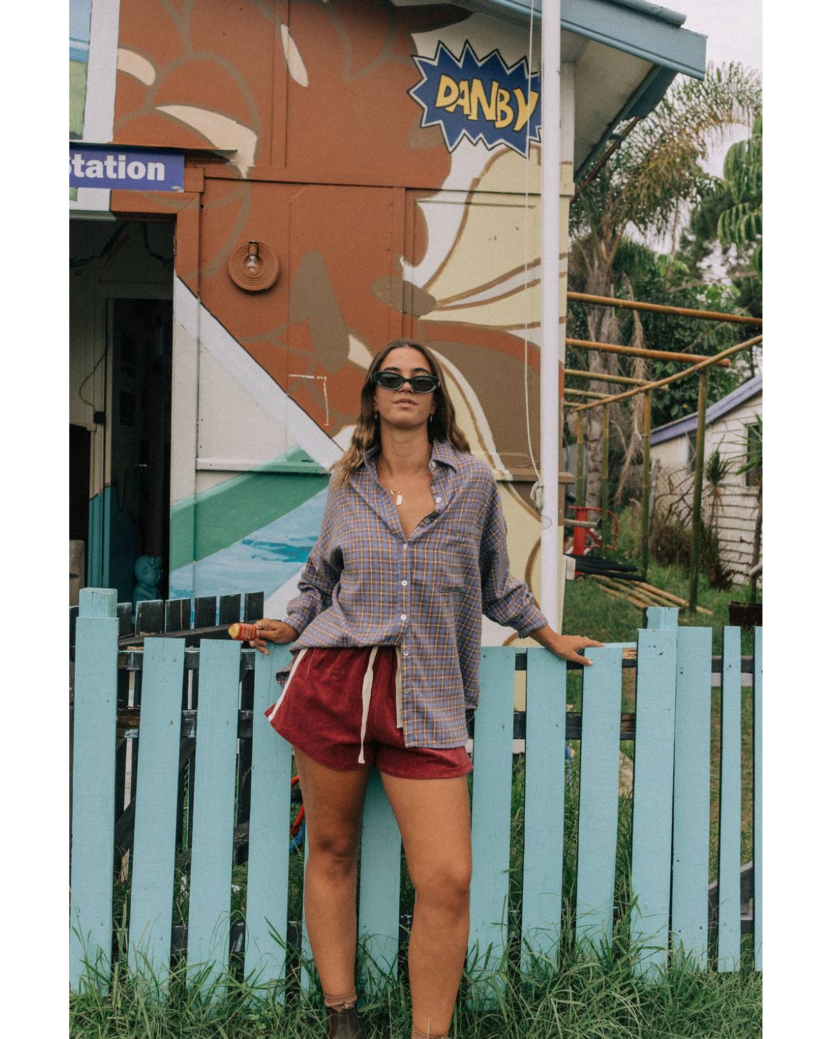 Model in flannel shirt by fence