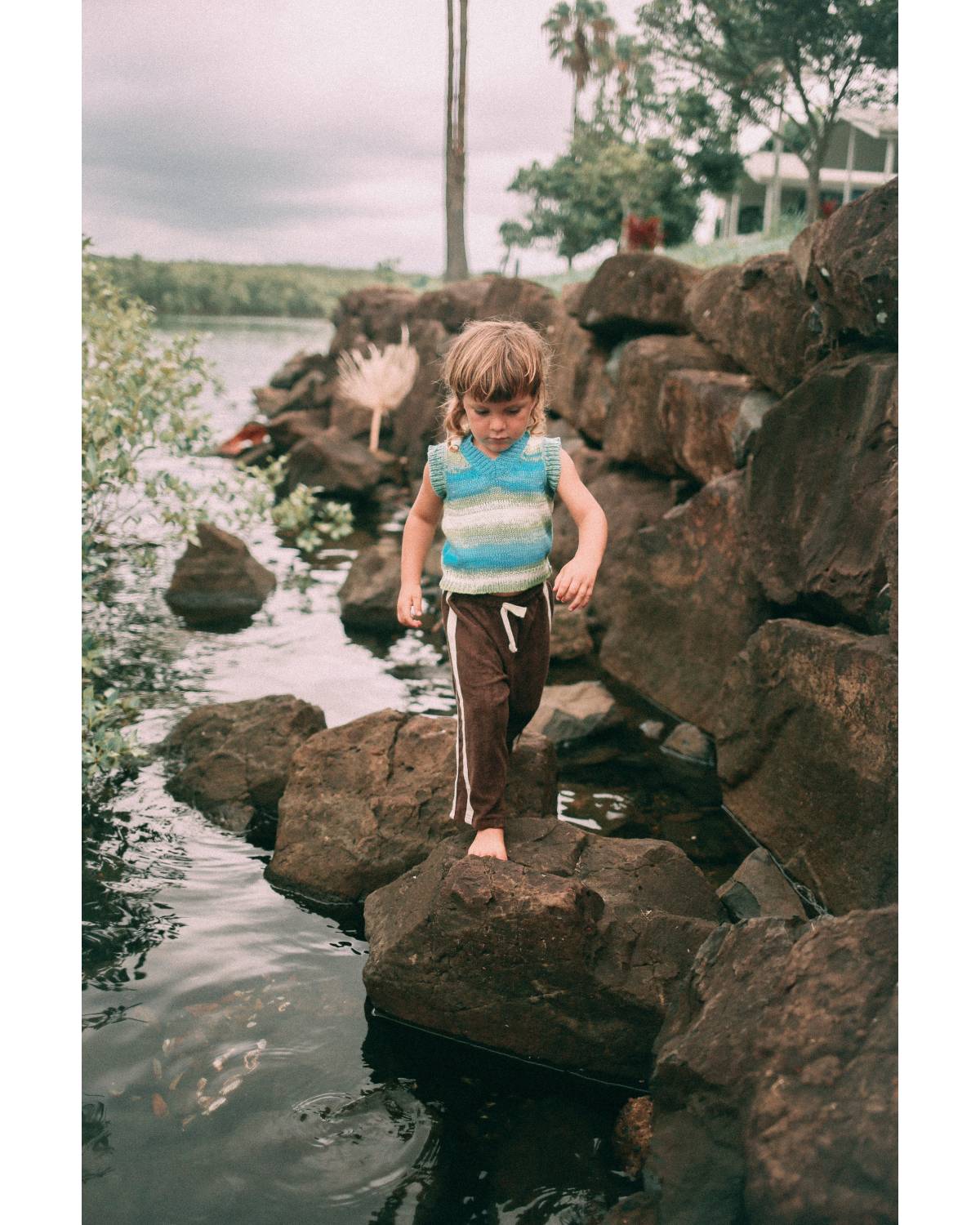 Child on rocks in vest
