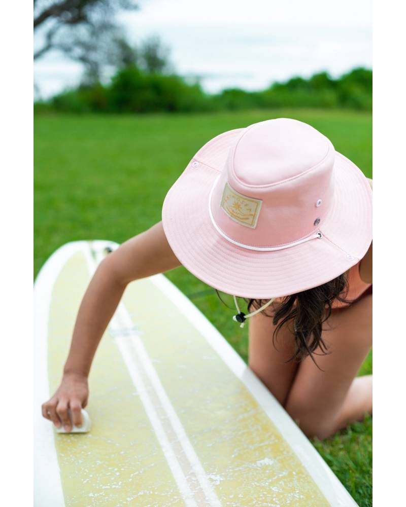 Atmosea The Surf Hat being worn by a surfer waxing their board