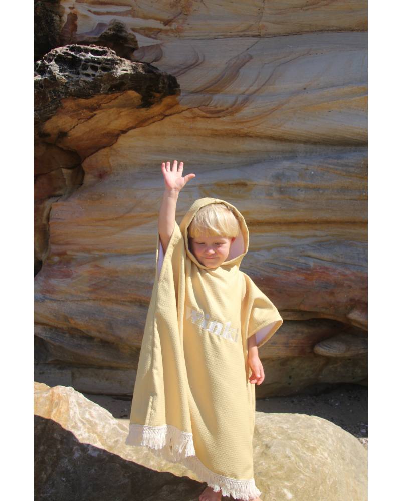 Child in mustard towel on stand