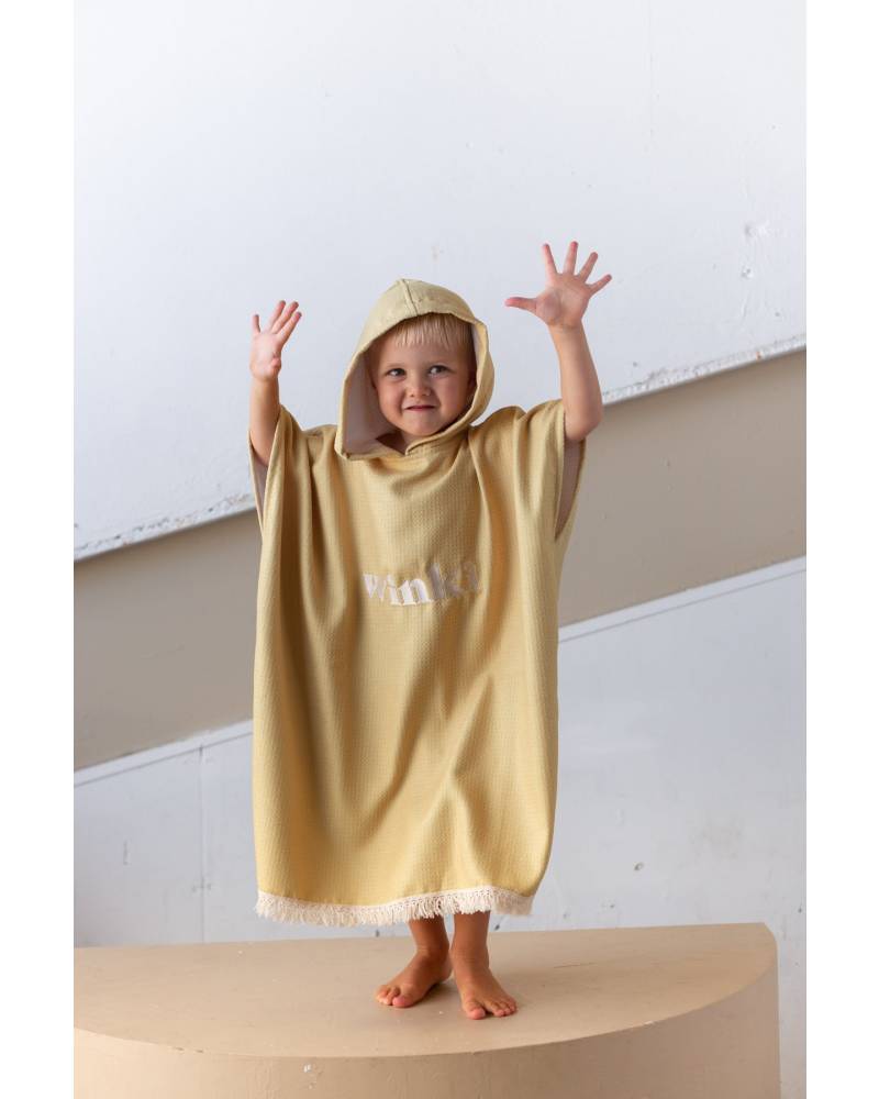 Child in mustard towel outdoors