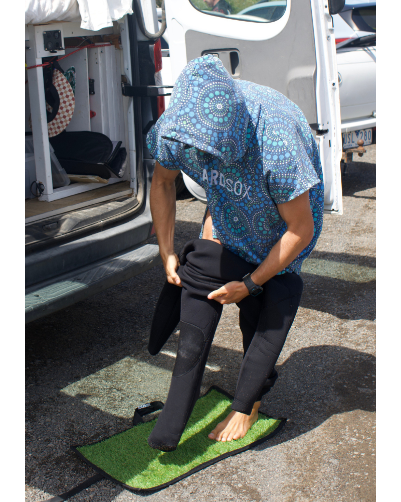 Person changing on sand mat