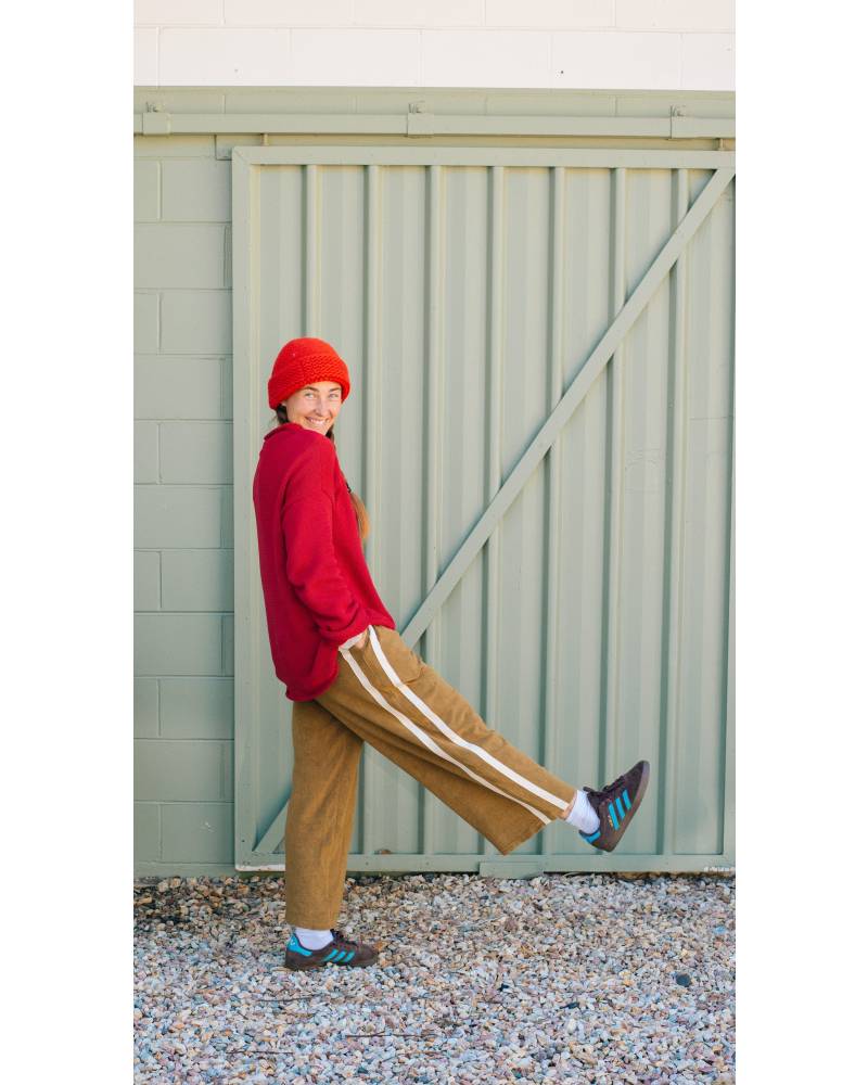 Model in red sweater, green pants