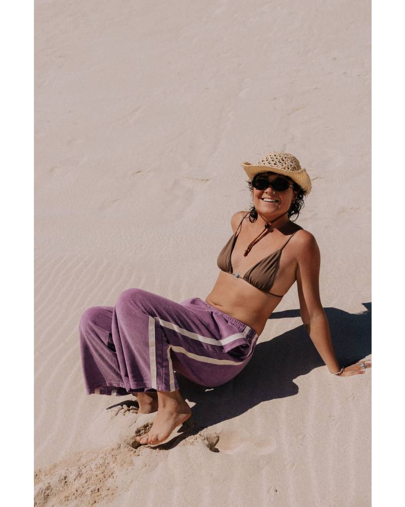 Model on sand in purple pants
