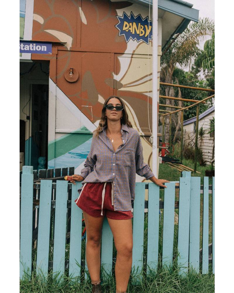Model in flannel shirt by fence