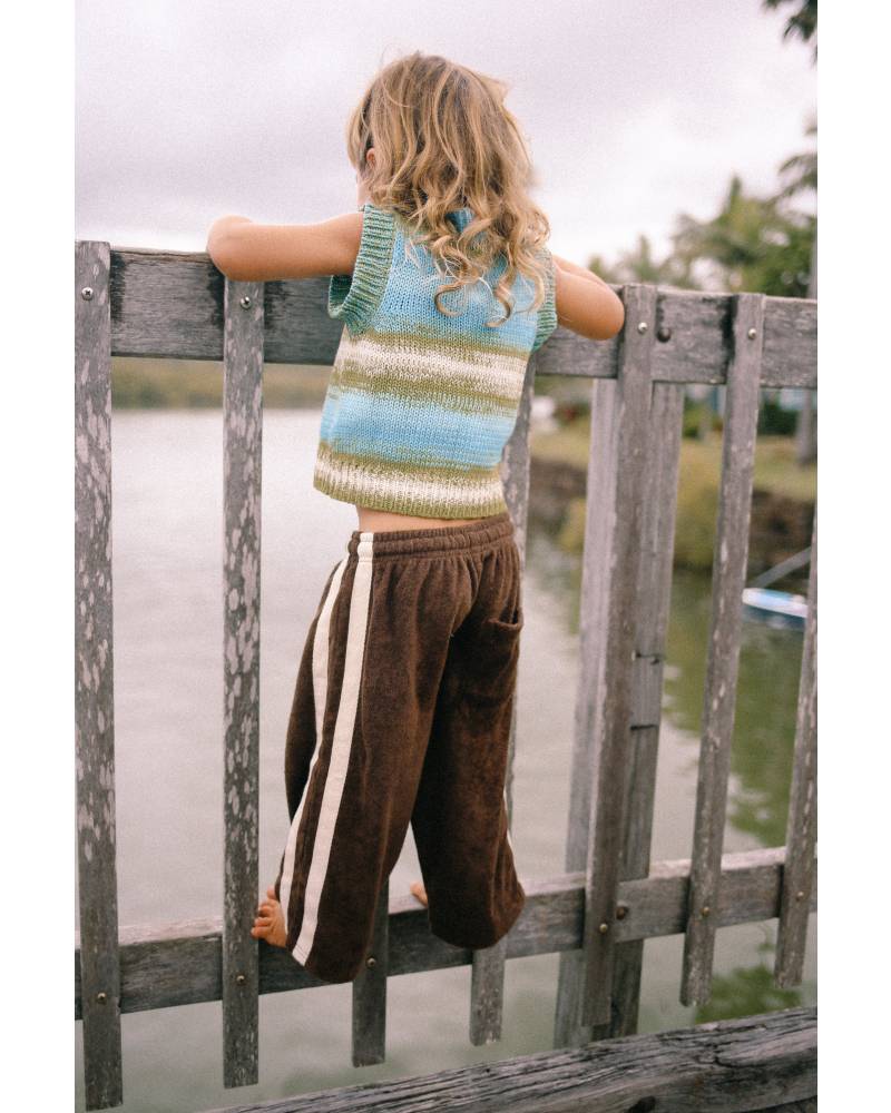 Child climbing fence in vest