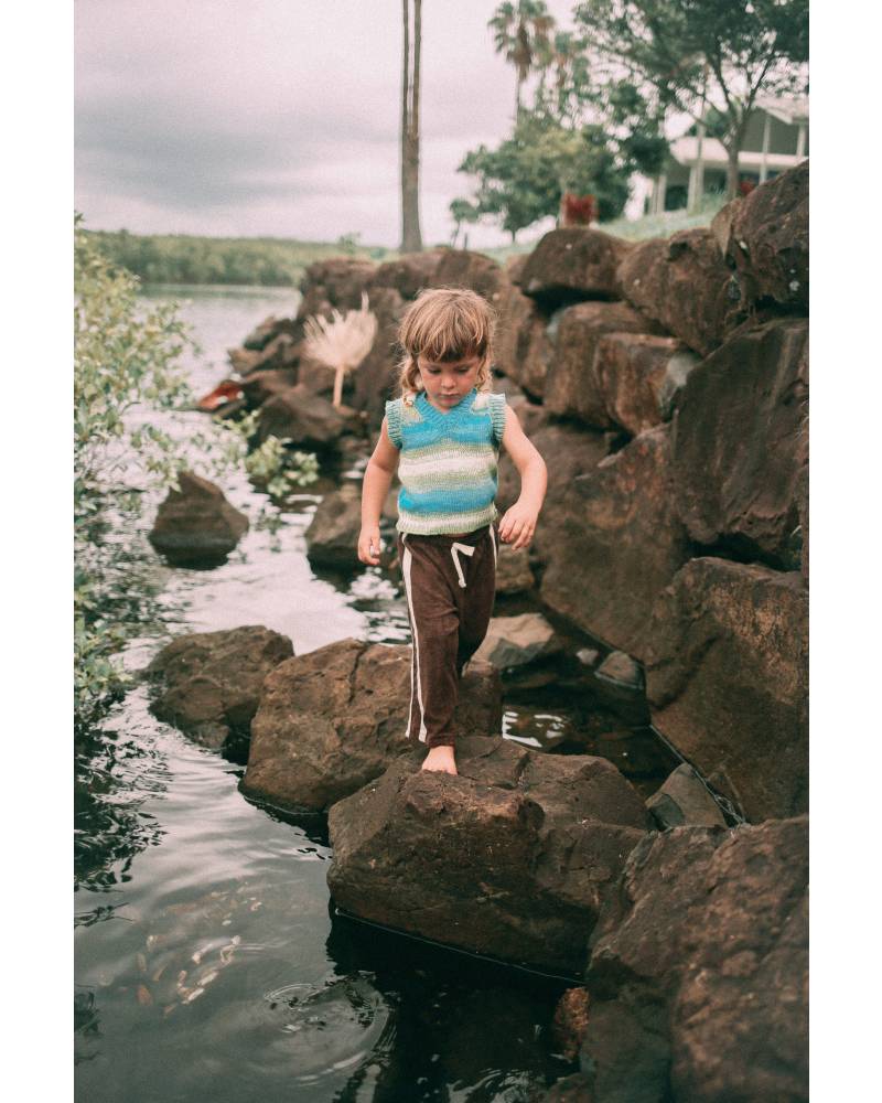Child on rocks in vest
