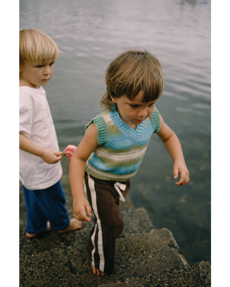 Child climbing fence in vest