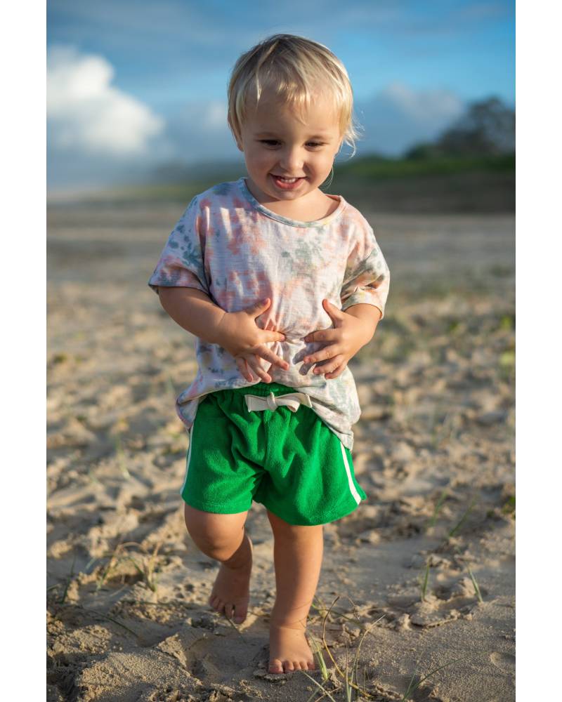Child in green shorts running