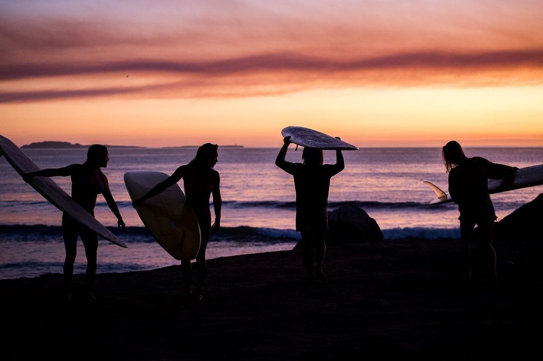 surfers at sunset